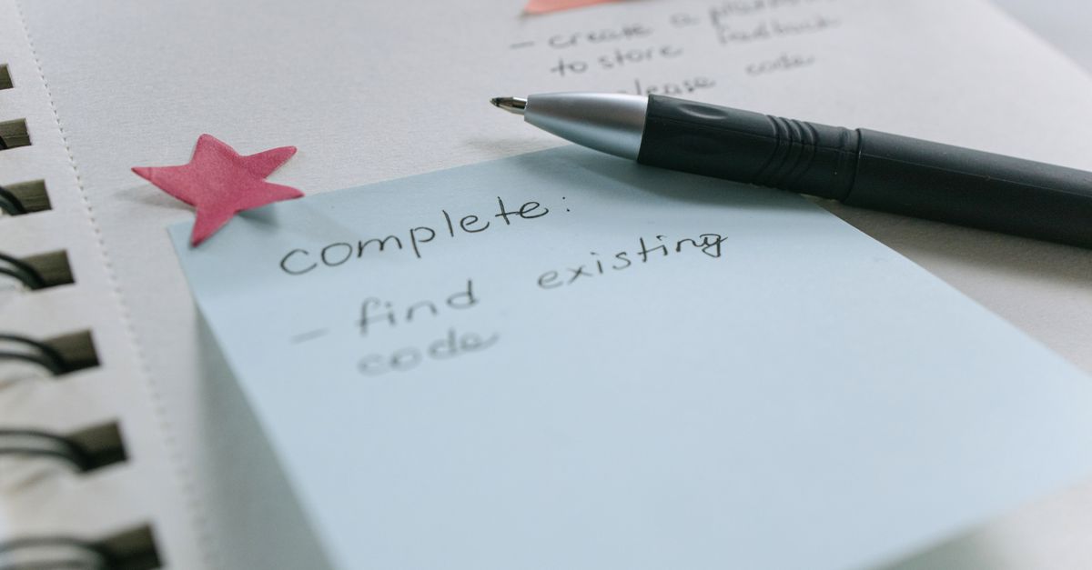 A notebook of collected customer questions with sticky notes on a content planning desk.